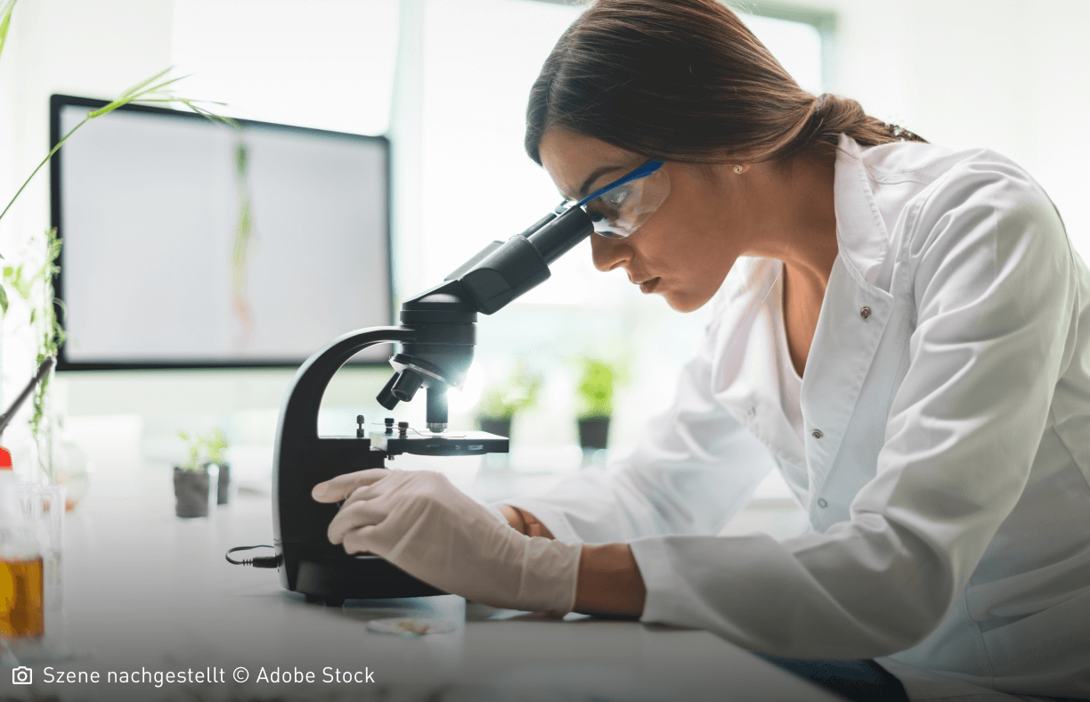 Junge Frau schaut konzentriert in ein Mikroskop: Fortschritte in der Molekulargenetik liefern neue Erkenntnisse bei der Ursachenforschung.